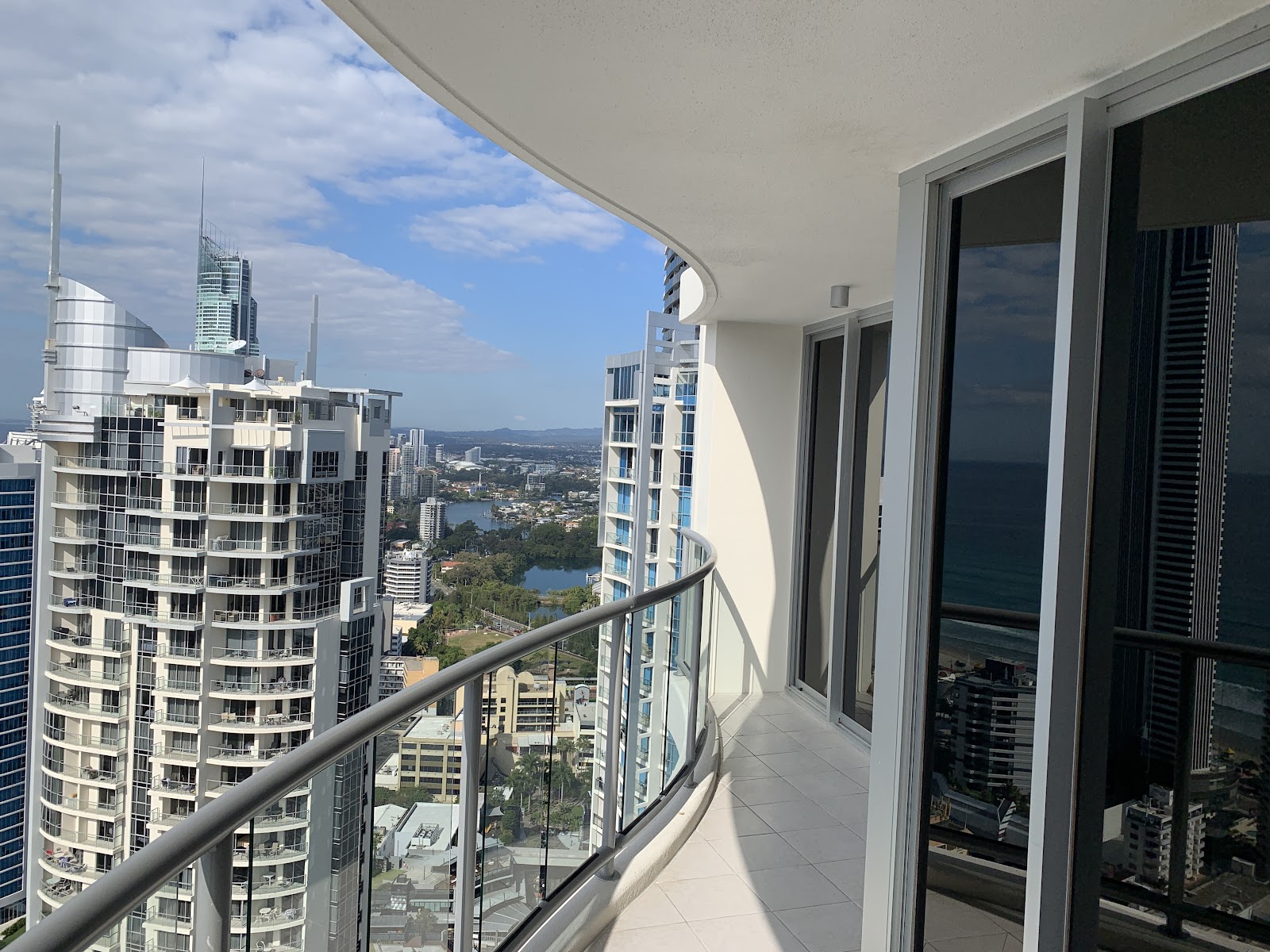 High-rise balcony with a clear glass balustrade and city view